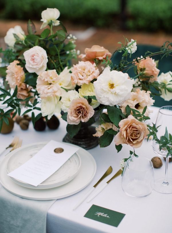 the table is set with white and pink flowers