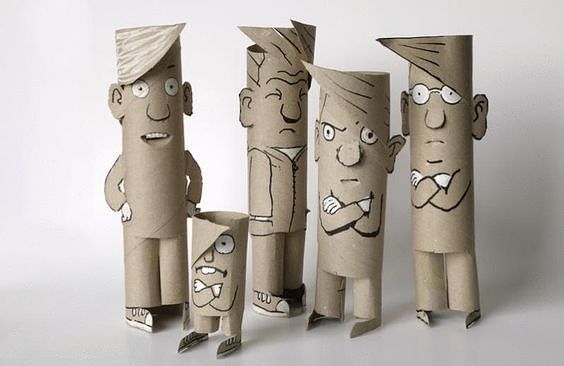 three cardboard figures with faces on them are standing next to each other