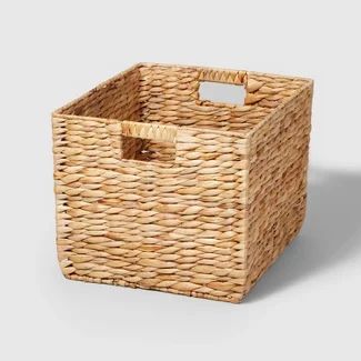 a wicker basket with handles on the side and an empty tag in the middle