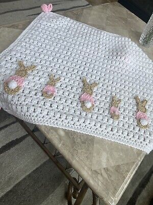 a crocheted table cloth with pink flowers and gold sequins on it