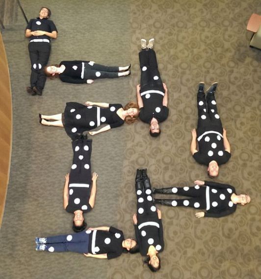 six women in black and white polka dot outfits laying on the floor