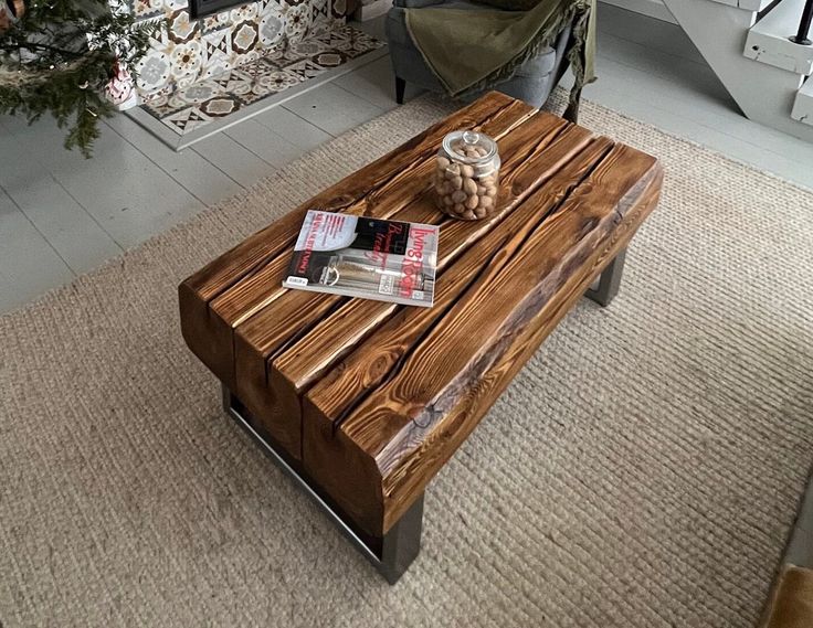 a wooden table sitting in front of a couch next to a christmas tree on top of a hard wood floor