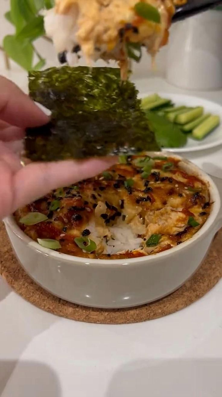 a person is dipping some food into a bowl