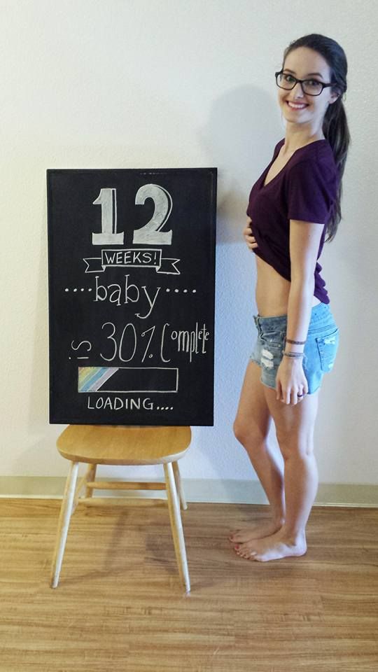 a woman standing in front of a chalkboard with the number 12 on it, next to a chair