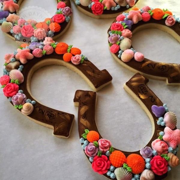 three decorated cookies shaped like the number twenty five with flowers and seashells on them