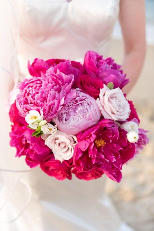 a bride holding a bouquet of pink and white flowers