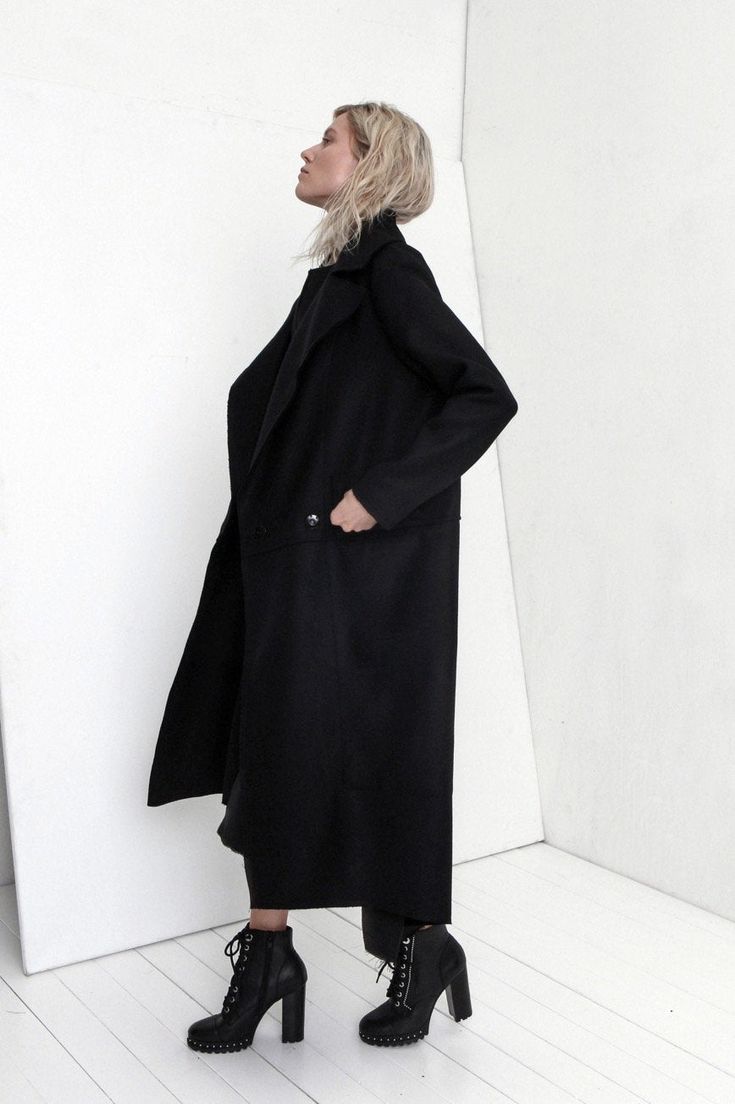 "Premium quality Black woolen coat has an oversize silhouette through the body , crafted in a heavy and thick high quality Italian wool fabric. Calf-length coat is fastened with two knobs. The coat has a unique cut , features big collar, long sleeves and is very stylish. This coat has a horizontal line through the front and back, there are large pockets in front. On one side on the shoulder is a decorative detail. The coat is with viscose lined. This coat is very stylish and unique created by a Black Wool Coat With Pockets For Winter, Black Wool Coat With Pockets For Cold Weather, Oversized Black Wool Coat For Winter, Oversized Long Wool Coat For Spring, Spring Oversized Long Wool Coat, Black Long Pea Coat With Pockets, Oversized Black Sweater Coat For Winter, Oversized Long Sweater Coat In Solid Color, Oversized Long Wool Coat For Work