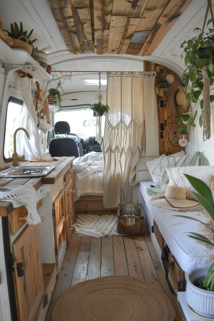 the interior of an rv with wood flooring and plants in pots on the windowsill