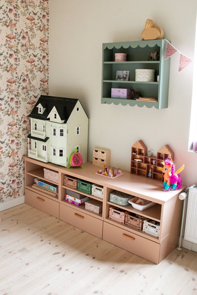 a toy house is sitting on top of a shelf in a child's room