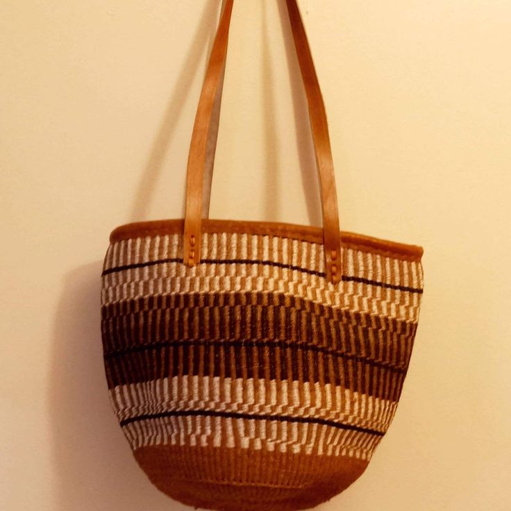 "This is a purely hand woven bag using the finest sisal threads dipped in permanent colors , The basket is mainly weaved using final sisal and handcrafted by rural women from the Akamba community The bag has cotton lining and  leather straps DIMENSIONS ( inches) Height 14 \" x width 12\" ALL orders ship via Dhl Express (3-5 days ) delivery. The bag is ready to ship. Height-14inches  Width-12- inches Closure Zipper" Handwoven Leather Bucket Bag For Everyday, Traditional Bucket Bag With Leather Handles For Daily Use, Everyday Handwoven Leather Bucket Bag, Handwoven Leather Bucket Bag For Daily Use, Handwoven Leather Bucket Bag With Double Handle, Handwoven Leather Double Handle Bucket Bag, Handwoven Leather Bucket Bag, Leather Handwoven Shoulder Bag, Artisan Handwoven Leather Bag