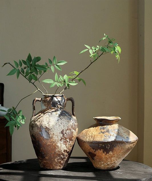 two vases with plants in them sitting on a table