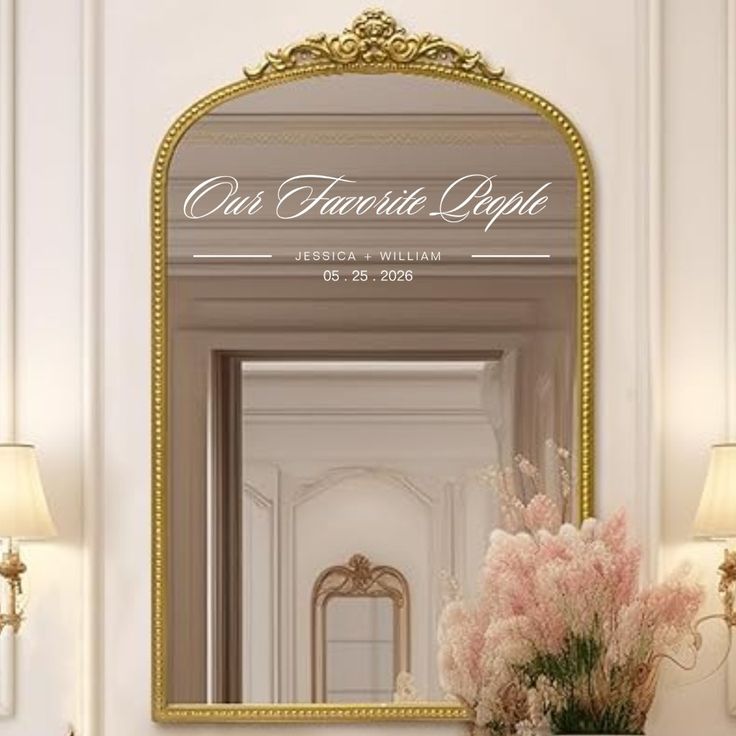 an ornate gold framed mirror on the wall above a vase with flowers in front of it