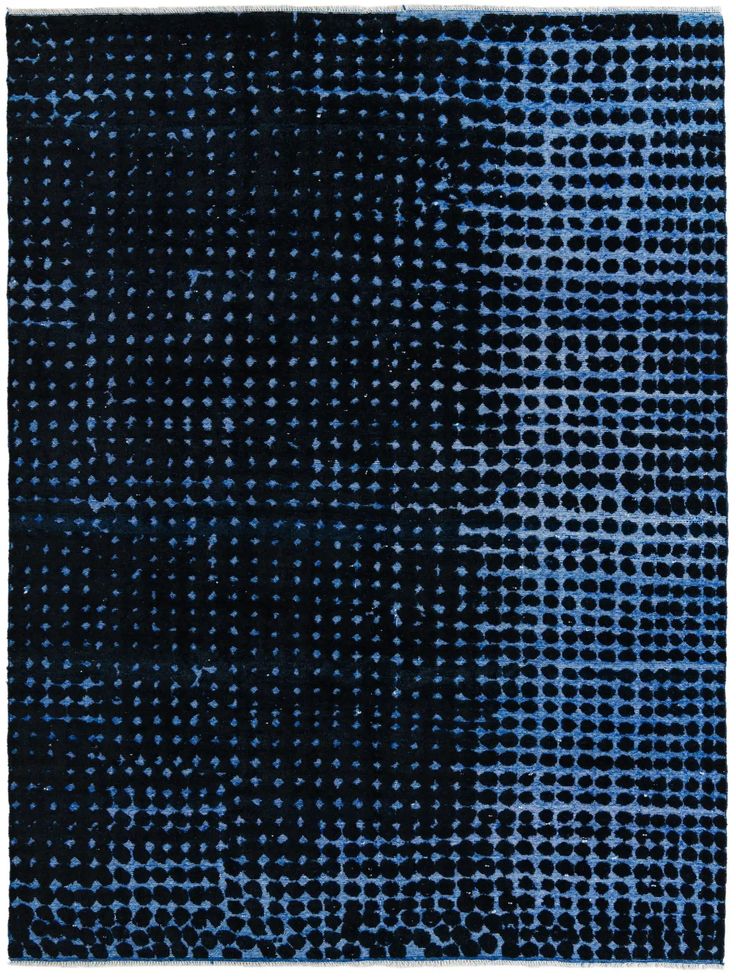 a blue and black area rug with small dots on the top, in an irregular pattern