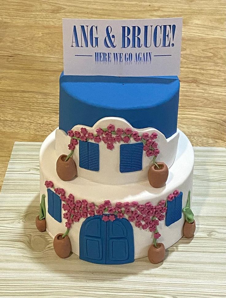 a three tiered cake with blue doors and pink flowers on the outside is displayed