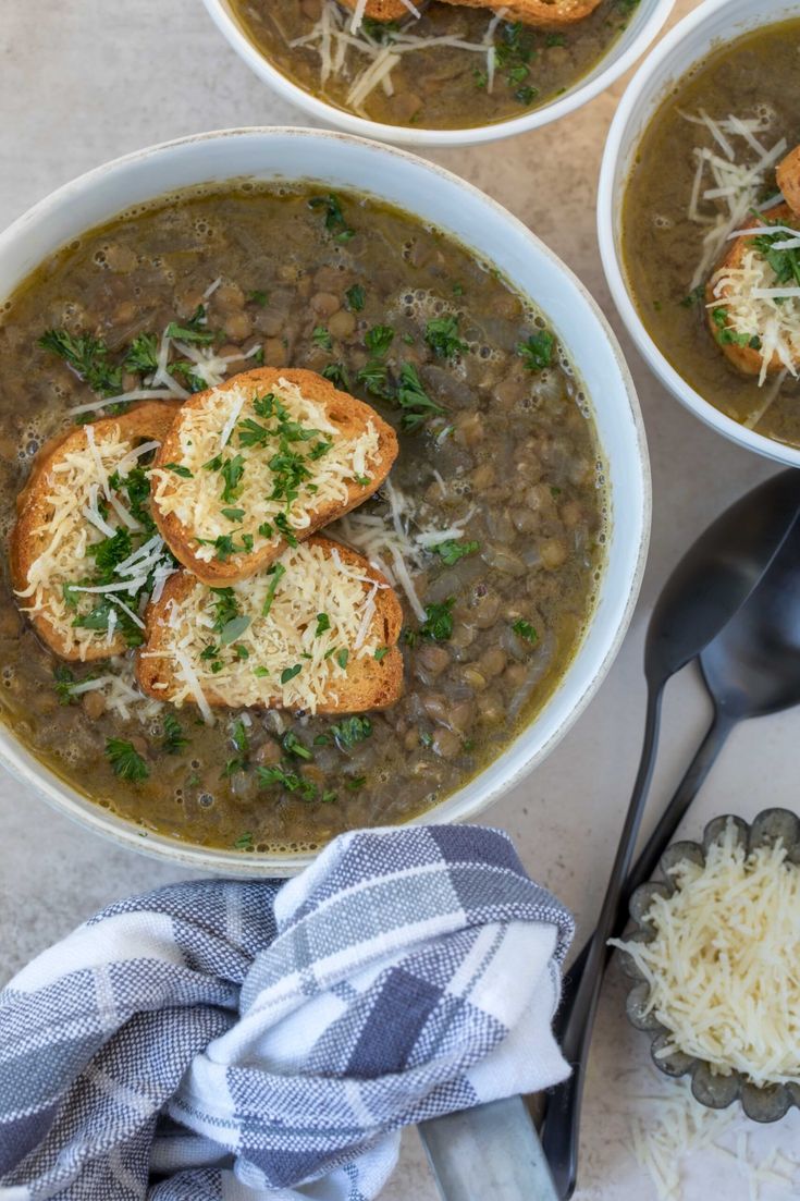 three bowls of soup with bread and parmesan cheese