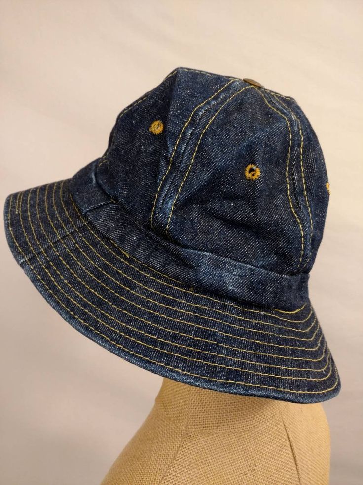 "Well made and well loved classic bucket hat by Levi's. Vintage seventies. Condition very good, light wear from age but no damage, no stains. Stiffness to fabric, yellowing on sweatband. Dark wash cotton denim, ochre stitching. Copper color button on top with lettering Levi Strauss &Co SFCAL. Cotton. 2.25\" brim. inside circumference 22.5\", not stretchy but a bit of give. wt 5oz" Vintage Blue Short Brim Hat, Retro Wide Brim Bucket Hat, Retro Blue Bucket Hat, Retro Blue Bucket Hat With Curved Brim, Vintage Denim Bucket Hat, Vintage Denim Brimmed Hat, Blue Retro Bucket Hat With Curved Brim, Vintage Cotton Hat With Curved Brim, Vintage Brimmed Denim Hat