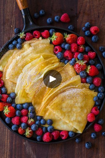 the video shows how to make crepes with fresh berries and blueberries in a skillet