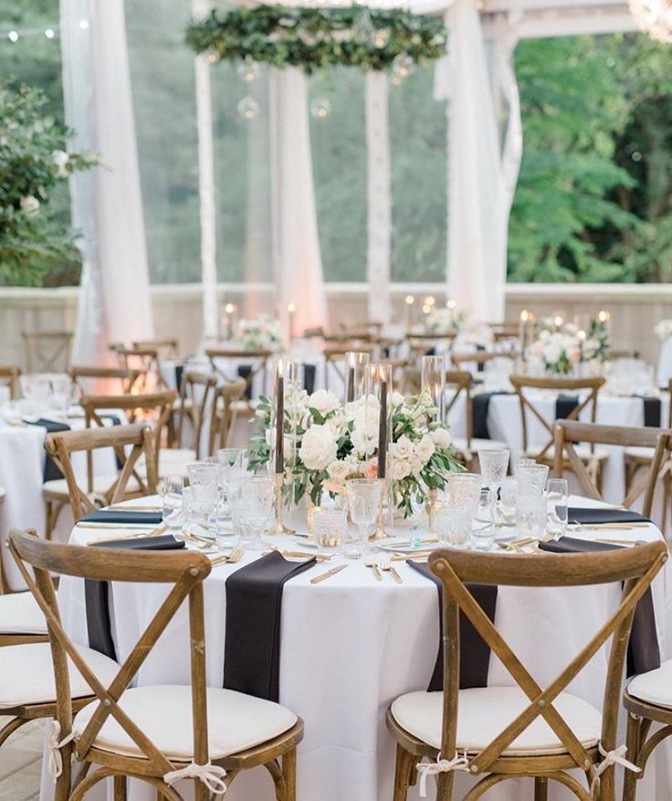 the tables are set up with white and black linens for an elegant wedding reception