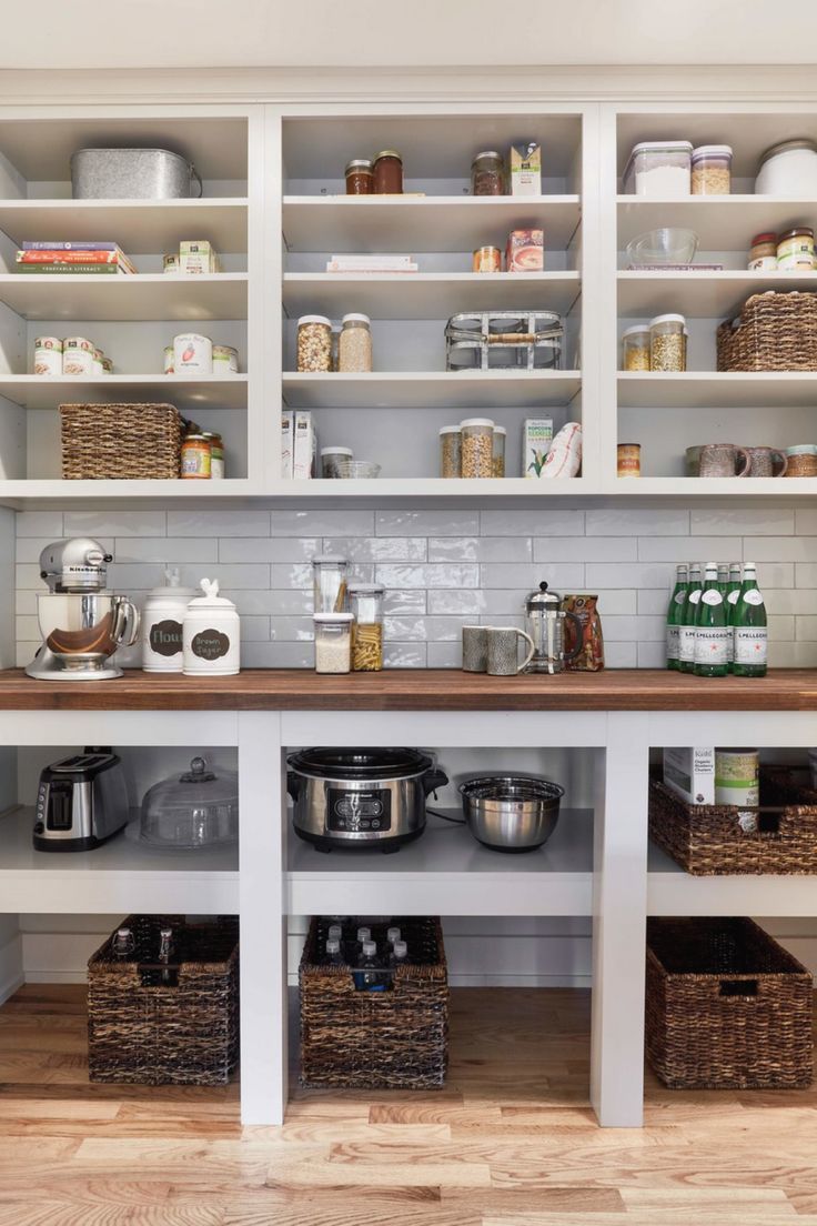 a kitchen with white cabinets and shelves filled with pots, pans and other items