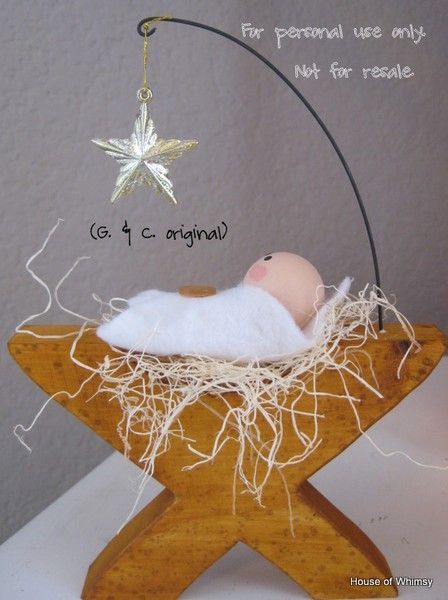 a wooden star ornament with a baby in it