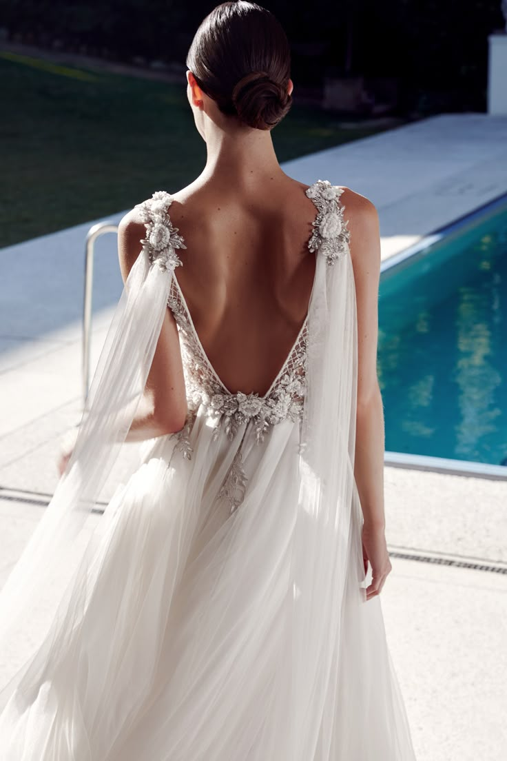 the back of a woman's dress in front of a swimming pool