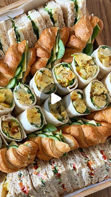 a platter filled with lots of different types of sandwiches on top of each other