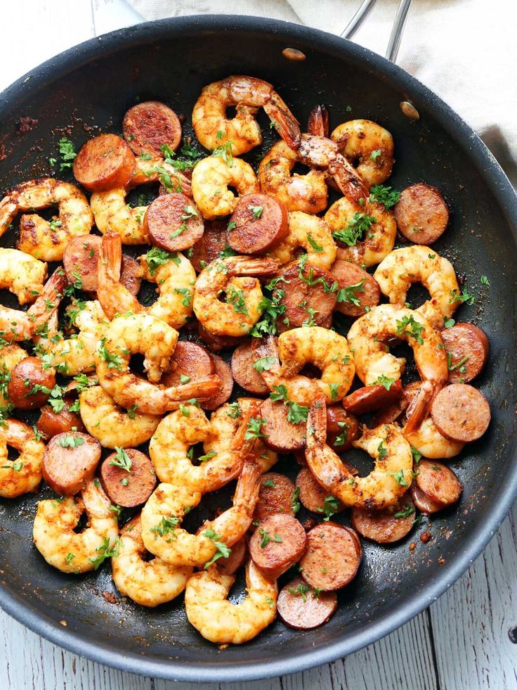 shrimp and sausage in a skillet with the title above it reads cajun shrimp and sausage