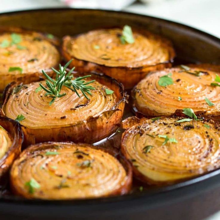 baked potatoes with herbs in a pan on a white counter top, ready to be eaten