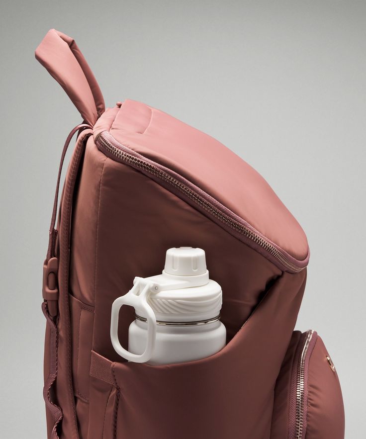 a pink backpack with a water bottle in it