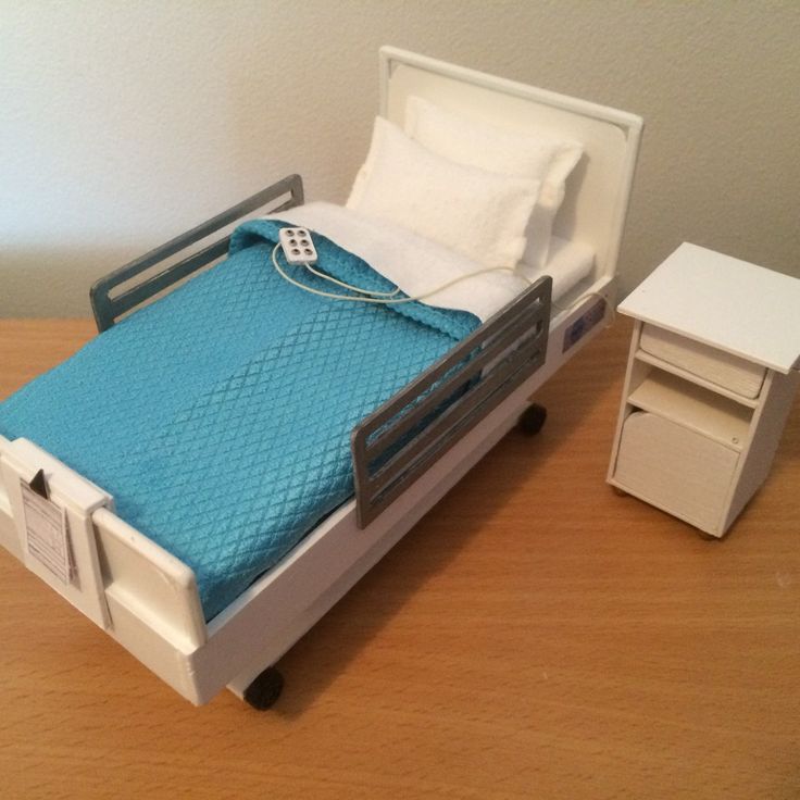 a toy hospital bed and nightstand on a wooden table