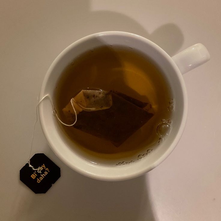 a cup of tea is sitting on a table next to a tag that says, don't drink it