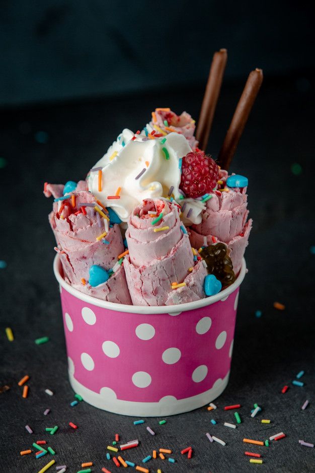 a pink polka dot cup filled with ice cream and sprinkles