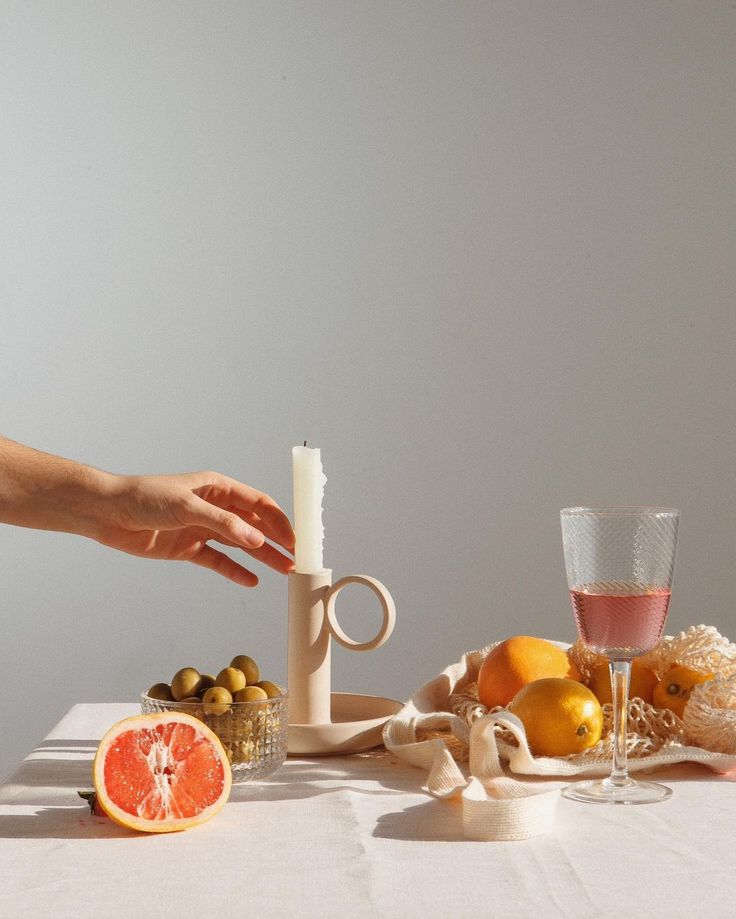 a person reaching for an orange on a table