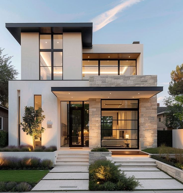 a modern house with large windows and steps leading up to the front door that lead into the yard