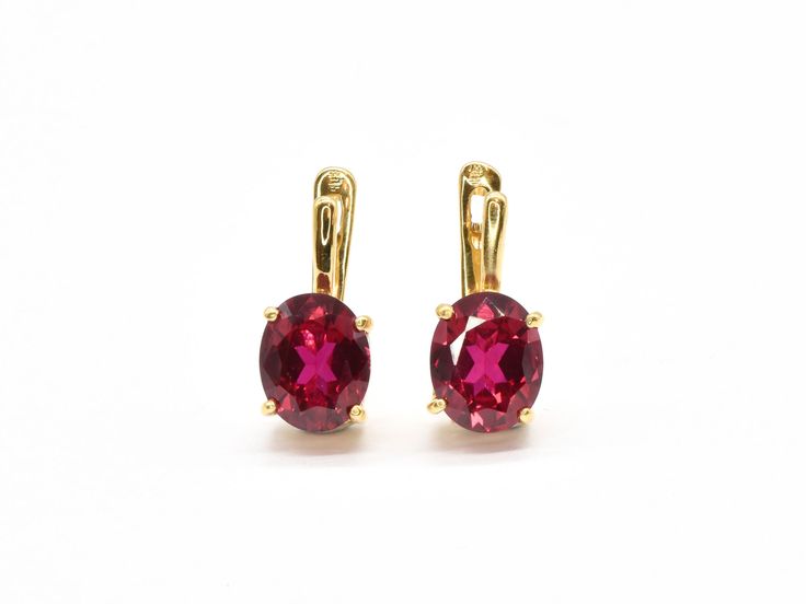 Red Ruby Earrings set with a Created Ruby in a perfect diamond cut & stunning red color with flawless clarity, at 10x8mm each (6 Cts a pair). Gold Vermeil: 18k Gold over Solid 925 Sterling Silver ☞ made to lastClick here for ☞ Matching PendantClick here for ☞ Matching Ring Details:• Created Ruby in a flawless clarity• Ruby: 10x8mm each, 6 Cts a pair, diamond cut• Lever Back Closure - "English Lock"• Dimensions: Length 17mm, Width 10mm• 18k Gold Vermeil SKU 2829 Classic Red Ruby Earrings, Red Oval Ruby Earrings, Single Ruby Earring In Red, Gold Ruby Earrings, Ruby Gemstone Earrings Round Cut, Red Gemstone Earrings In 14k Gold, Red Ruby Earrings, Oval Earrings, Matching Ring