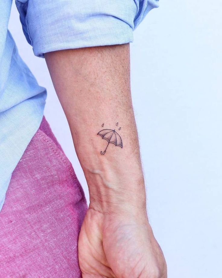 a woman's arm with an umbrella tattoo on it