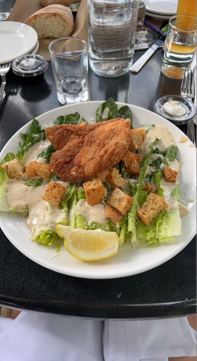 a white plate topped with lettuce and chicken