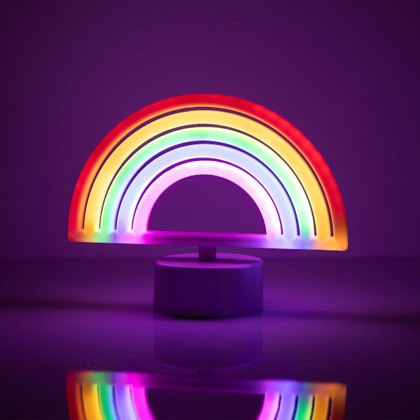 a rainbow light sitting on top of a table next to a purple wall and floor