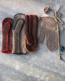 three knitted mittens are sitting on top of each other, one is red and the other is gray