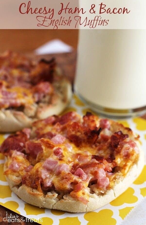 an english muffin with ham and bacon on it next to a glass of milk