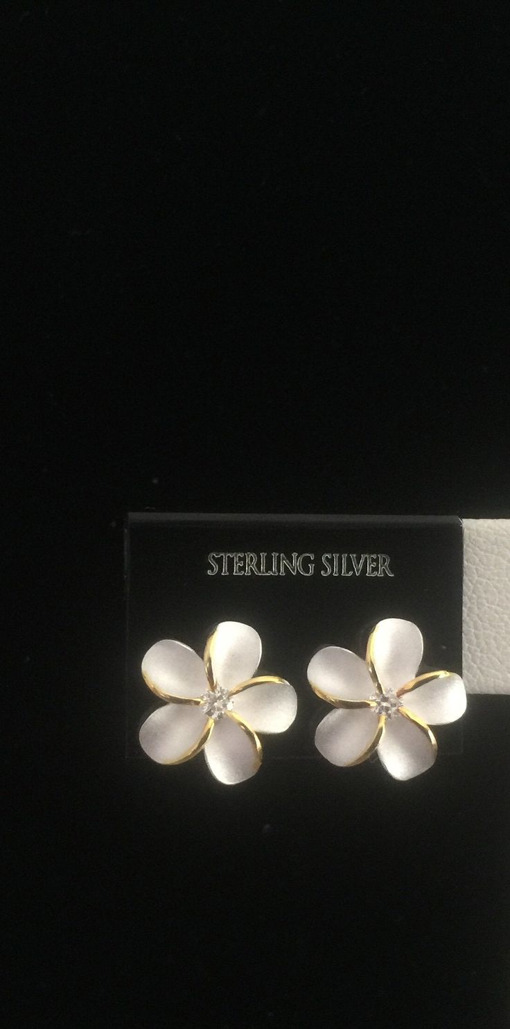 "Solid .925 Sterling Silver Hawaiian Plumeria 12MM (just under 1/2\") Stud Earrings. They have a Sandblasted Matte center with High-polished subtle 14K Gold edges and a Cubic zirconia in the Flowers center for a hint of bling. --The Plumeria is worn and often exchanged here in Hawaii as a symbol of love and friendship. --Packaged ready for gifting with a Hawaiian Plumeria story, Sterling silver cleaning instructions, a jewelry pouch and gift box." Nickel-free Flower Shaped Jewelry For Anniversary, Flower-shaped Hallmarked Earrings For Anniversary, Flower Shaped Hallmarked Earrings For Anniversary, Formal White Sterling Silver Flower Earrings, Nickel Free Flower Earrings For Anniversary, Nickel-free Flower Earrings For Anniversary, White Nickel-free Flower Earrings For Anniversary, Flower Shaped Pierced Jewelry For Anniversary, Flower-shaped Clip-on Jewelry For Anniversary