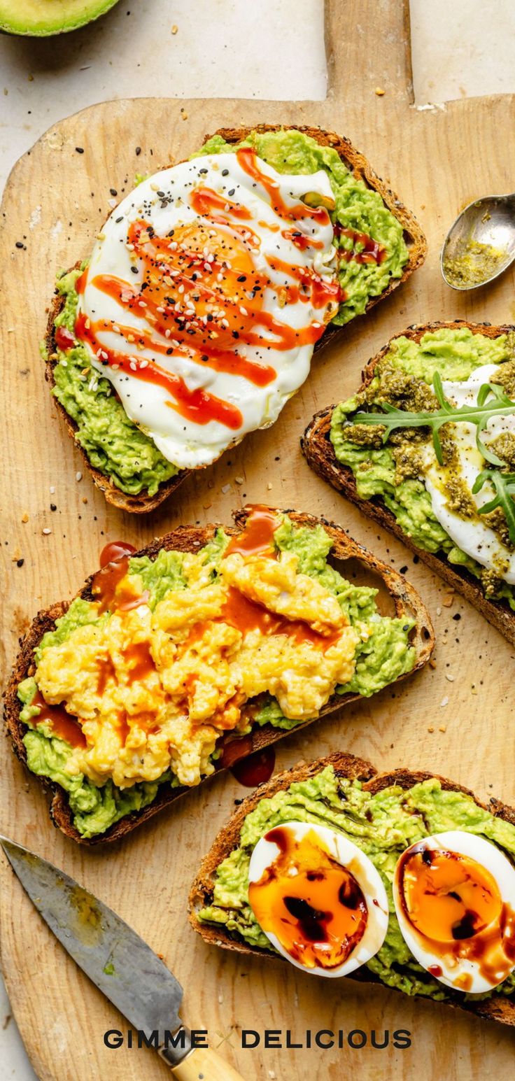 avocado toast topped with eggs and mayonnaise on a wooden cutting board