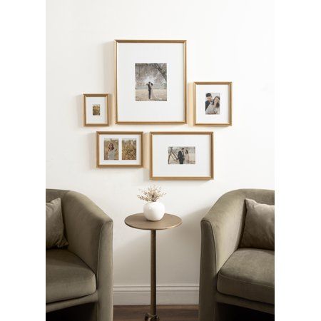 a living room with pictures on the wall and two chairs