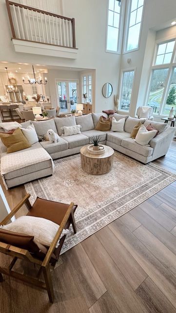 a living room filled with lots of furniture and large windows in the wall behind it