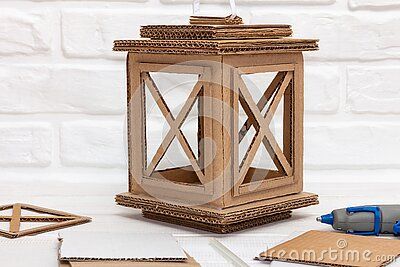 a wooden lantern and some crafting supplies on a table