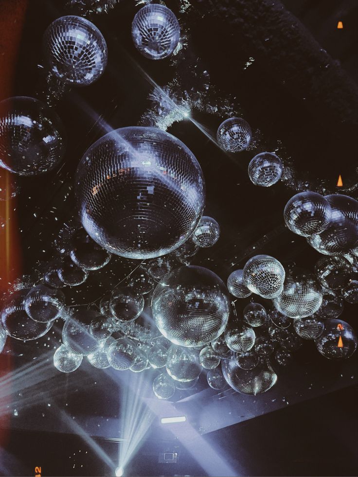 an array of bubbles floating on top of each other in front of a stage light