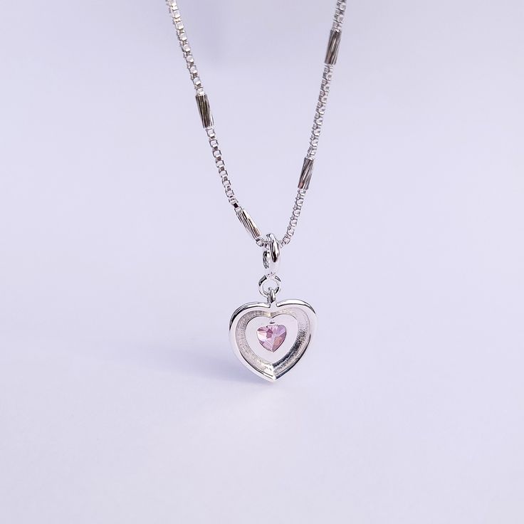 Introducing our Pink Glam Heart Necklace - crafted in Sterling Silver with a heart-shaped pink crystal at its core. This unique chain necklace features a sparkling pink crystal heart pendant, on a Sterling Silver heart shape base adding sophistication to any look. Wear it long or short with the adjustable clasp. Elevate your style with this enchanting piece that radiates love and glamour. Main Stone: heart shaped lab diamond Stone Color: pink Metal Material: 925 Sterling Silver Chain Lenght: 16 Silver Heart-shaped Crystal Necklace With Clavicle Chain, Pink Crystal Heart Pendant Jewelry, Crystal Heart Cut Necklace With Heart Charm, Pink Crystal Heart Pendant Necklace, Pink Heart-shaped Jewelry With Clavicle Chain, Pink Heart-shaped Clavicle Chain Jewelry, Silver Heart Cut Crystal Necklace For Valentine's Day, Heart Shaped Crystal Jewelry With Adjustable Chain, Heart Shaped Crystal Necklace With Adjustable Chain