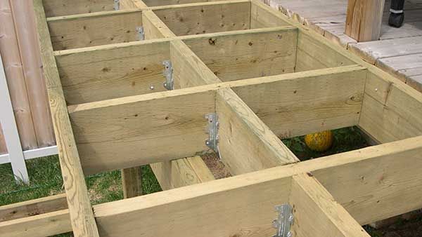 the bottom half of a wooden box with holes in it and some grass on the ground