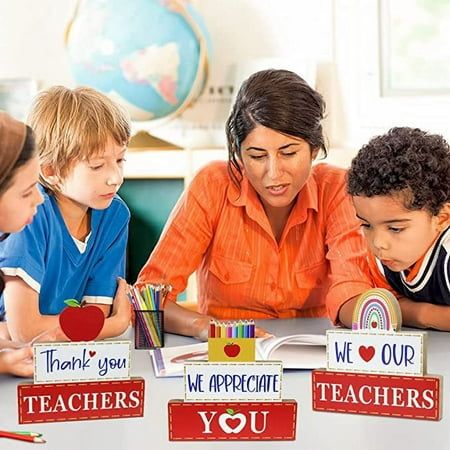 a woman and children are sitting at a table with teacher's blocks