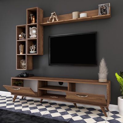 a living room with a large tv on the wall and shelves in front of it